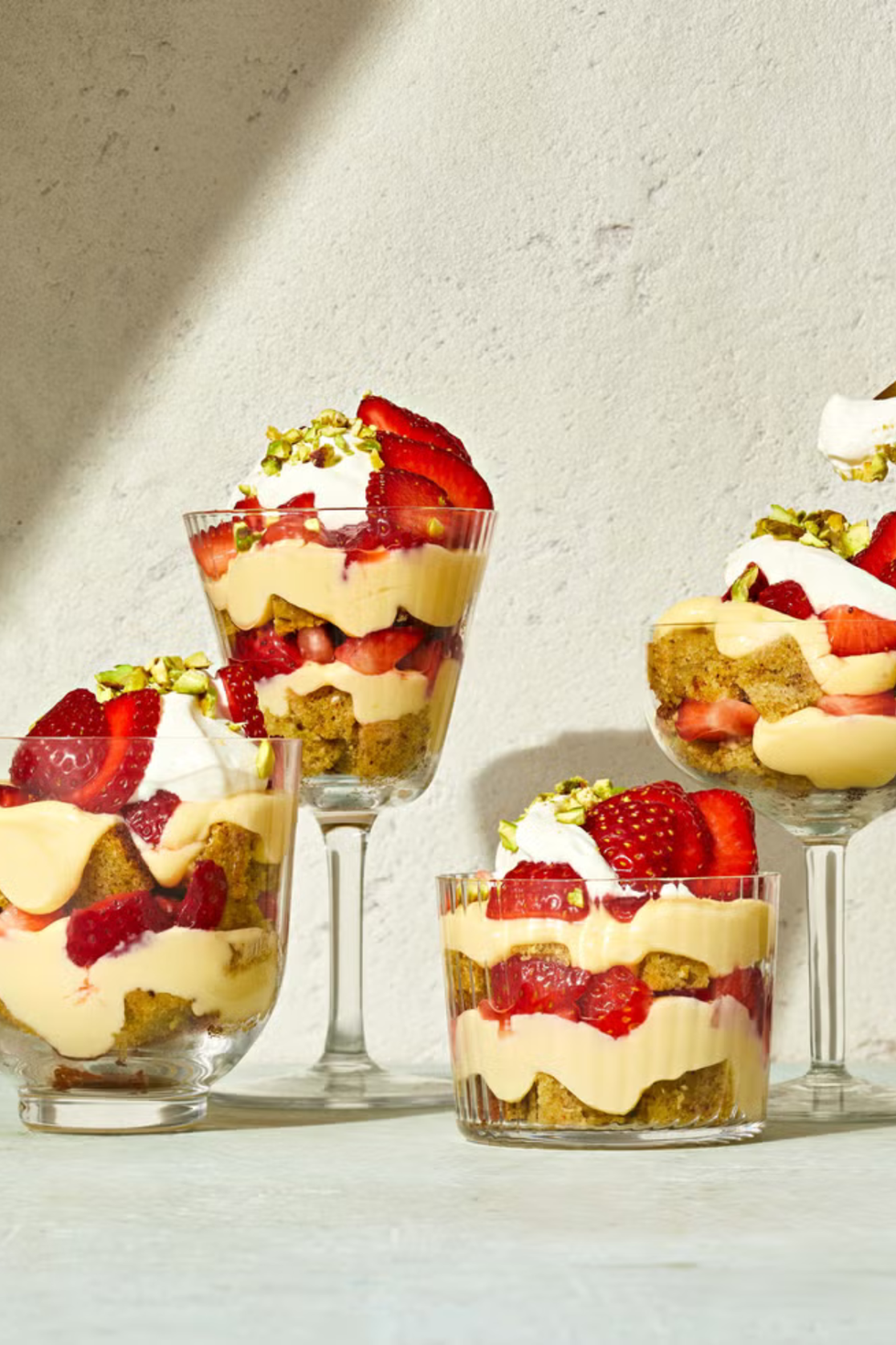 strawberry pistachio cake parfaits in a clear glass cup