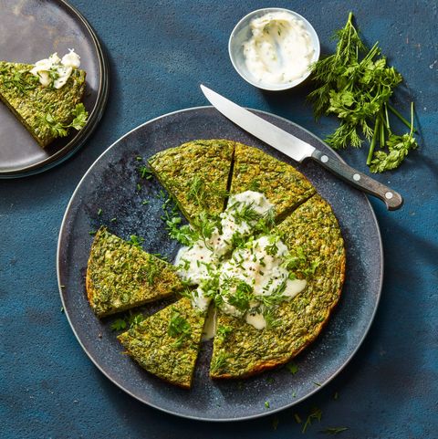 spring herb frittata on a speckled gray ceramic plate with a knife