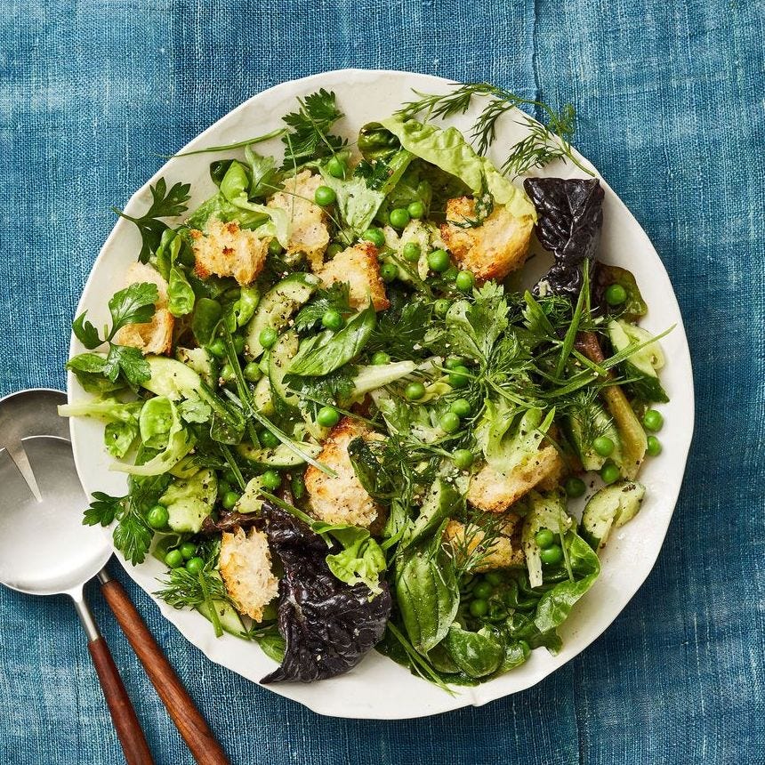 green spring panzanella salad in a white bowl