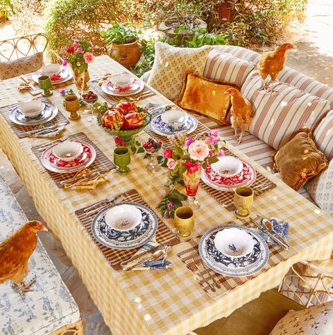 table with yellow tablecloth, dishes, and chickens