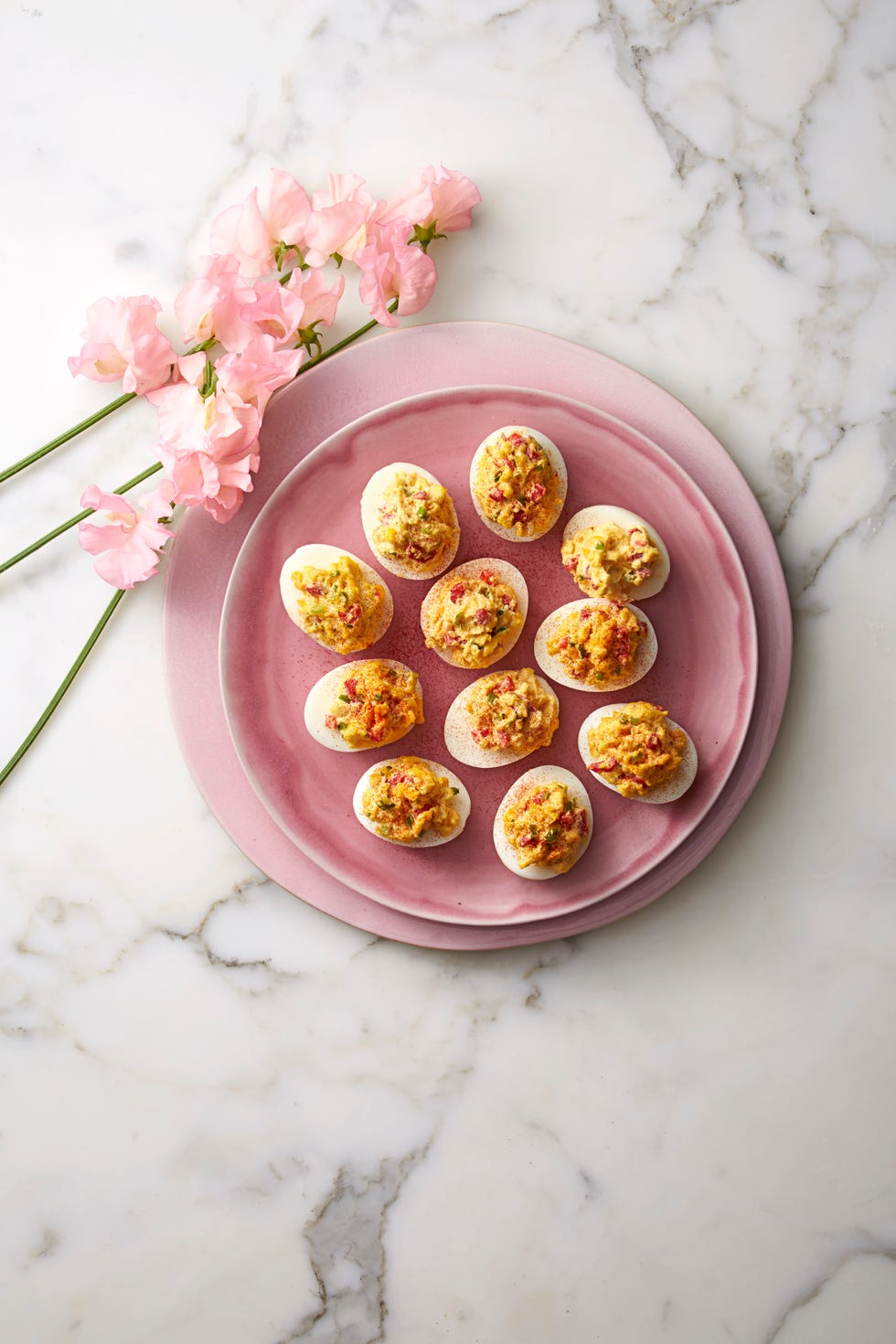 pimiento cheese stuffed deviled eggs on a pink plate