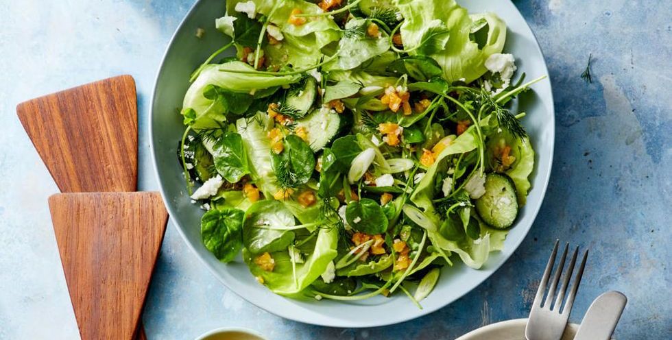 green spring salad with apricot vinaigrette on a blue plate