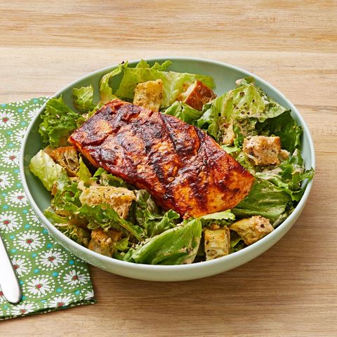 chipotle caesar salad with grilled salmon in bowl with green napkin