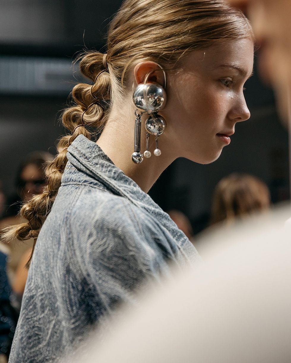 Kopenhag İlkbahar 2024 moda trendlerinde gestuz podyumunda gümüş küpeler takan bir model