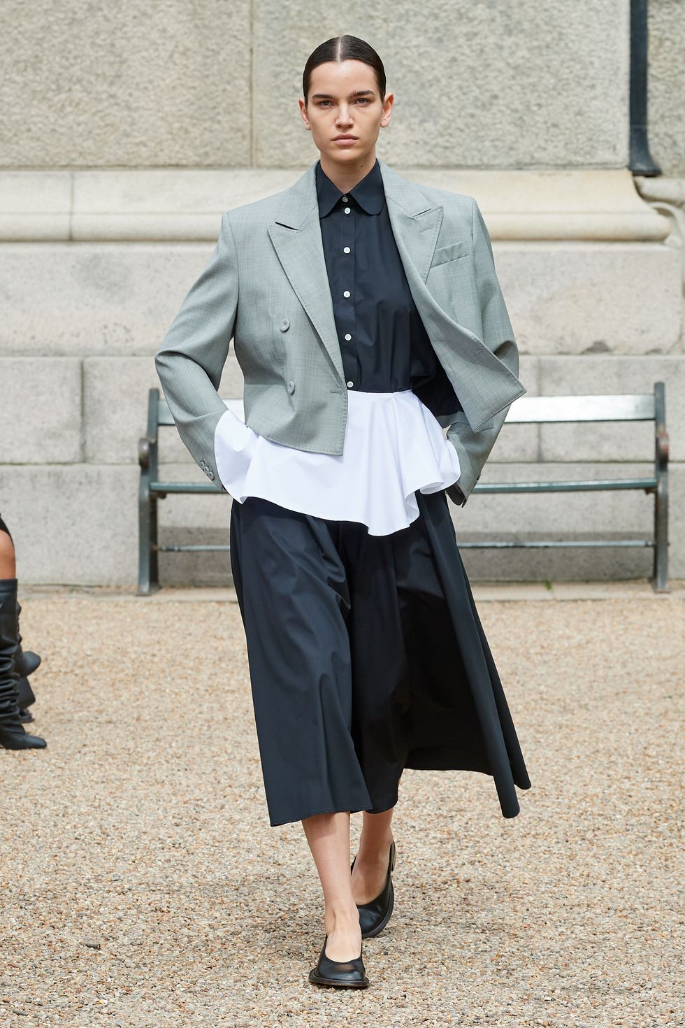 2024 ilkbahar moda trendleri kılavuzunda peplum etekli bir takım elbise giyen bir model