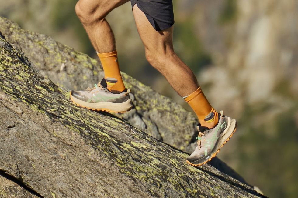 a person's legs and feet on a rock
