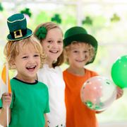 kids dressed up for st patricks day holding irish flag and balloons