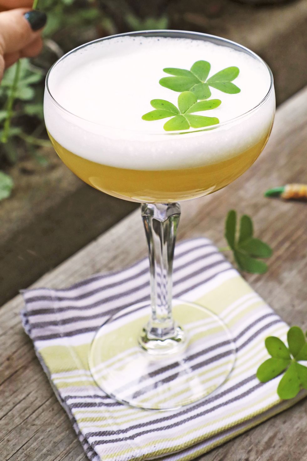 st patricks day cocktail with a four leaf clover as garnish