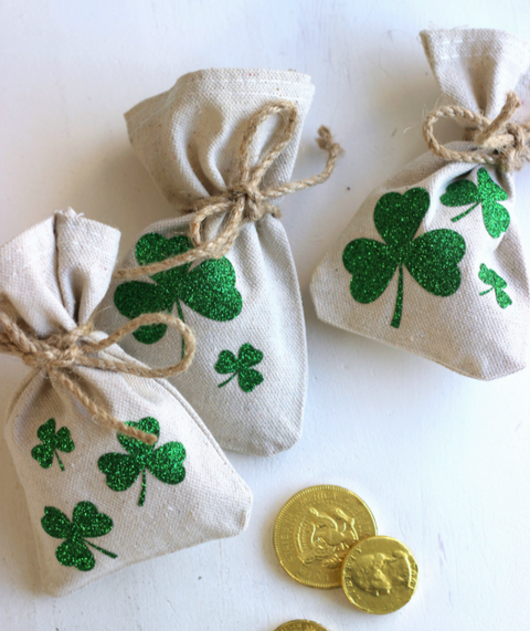 st patrick's day crafts, small white coin bags with shamrocks designed on the front