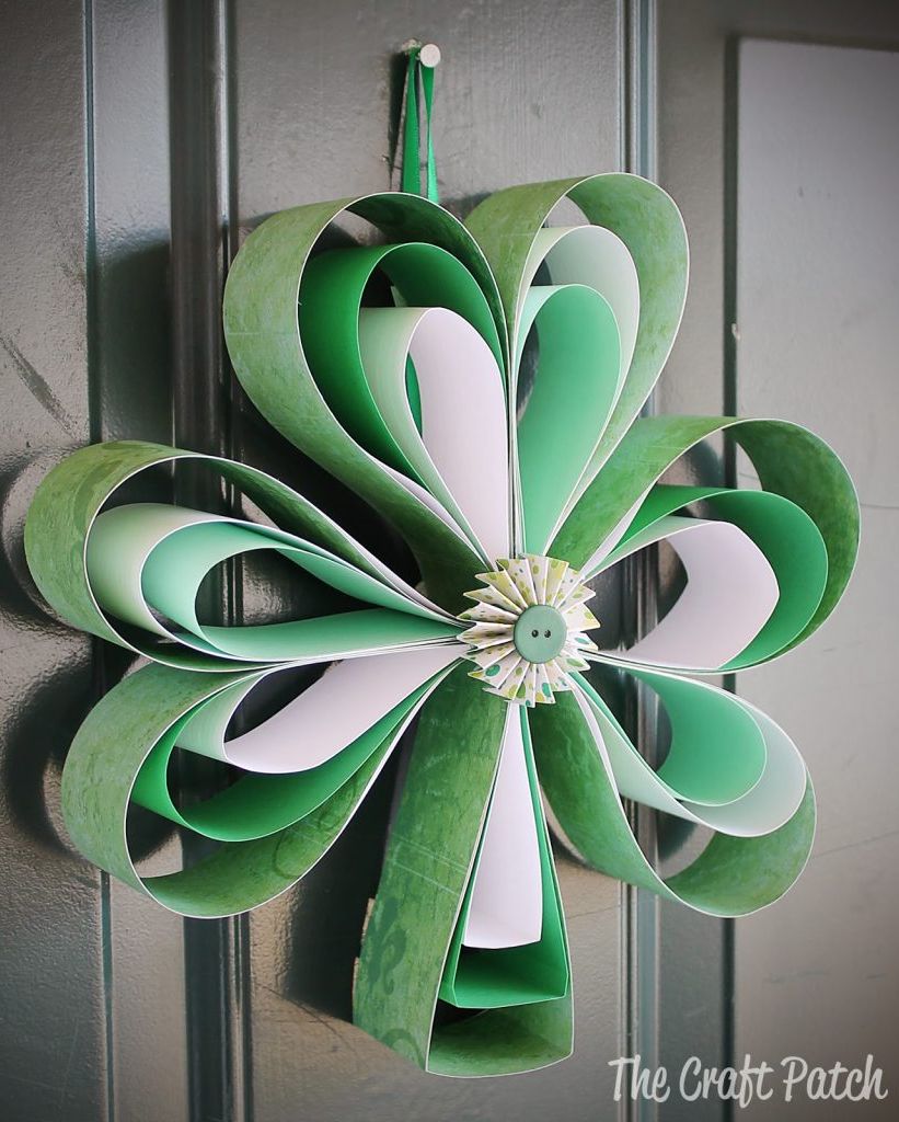 shamrock shaped green paper door hanger craft for st patrick's day, adorned with a green button in center