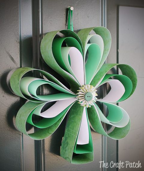 shamrock shaped green paper door hanger craft for st patrick's day, adorned with a green button in center