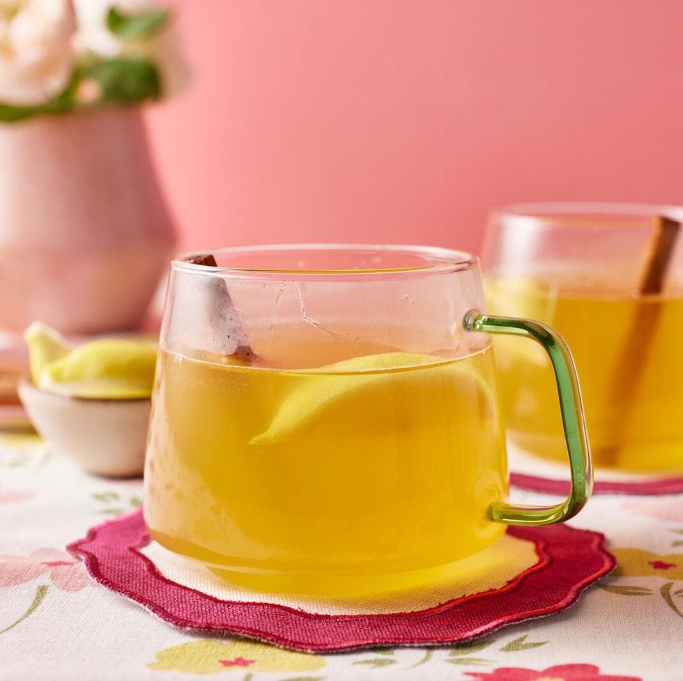 Hot toddy drink in a glass cup with lemon and cinnamon