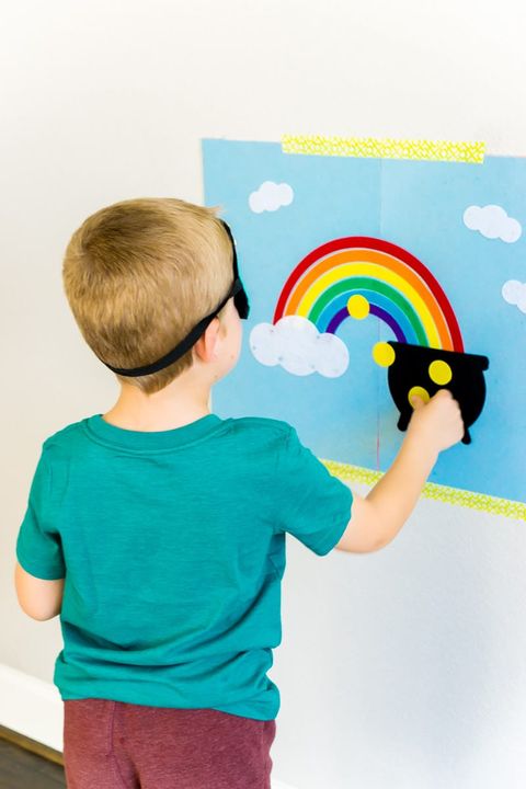 child wearing blindfold placing gold dots on picture of pot of gold at the end of a rainbow for a saint patrick's day game