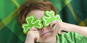 redhead and freckle face irish boy leprechaun with shamrock cookies over his eyes smiling irish child wearing green on st patricks see lightboxes below for more holdiday food and people backgrounds