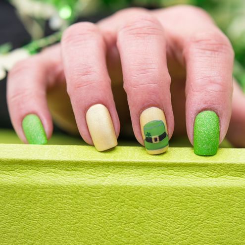 a st patricks day inspired manicure with a leprechaun hat painted on one nail