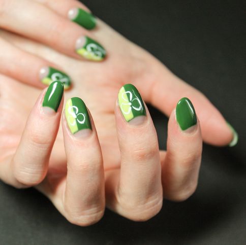 moon manicure gel polish with abstract bright and fashionable design with green shamrocks on the hands of a modern girl