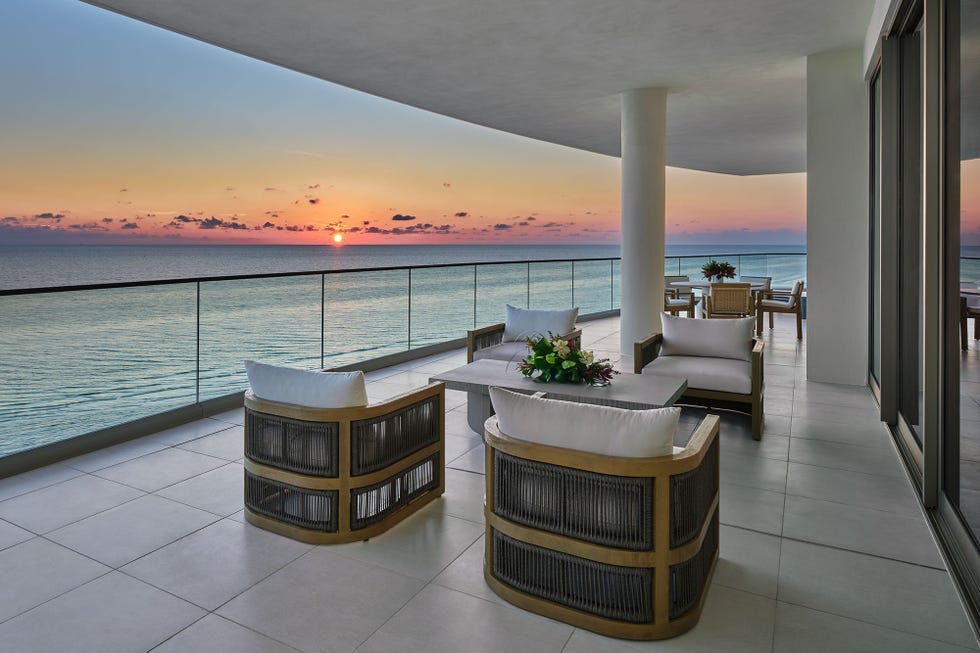 balcony seating area with ocean view at sunset