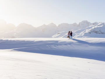 wedding couple shooting in the mountain of engadin in winter time with snow and panorama views