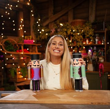 stacey solomon holding two nutcrackers in a christmas barn