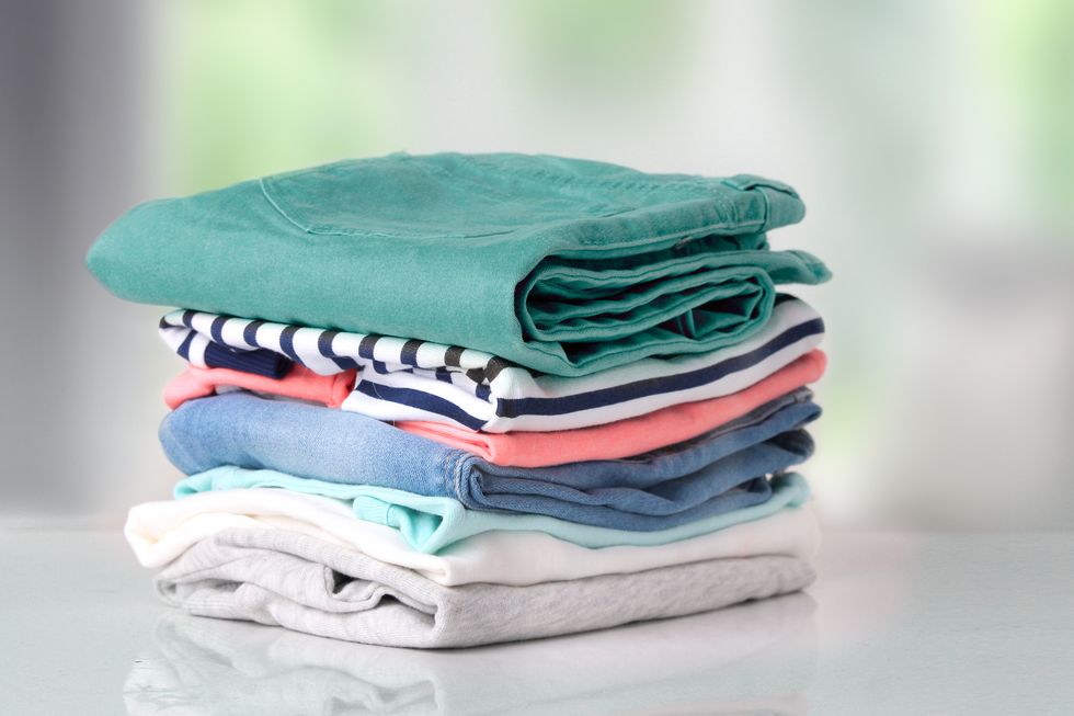 Stack colorful cotton clothes on table empty space background.