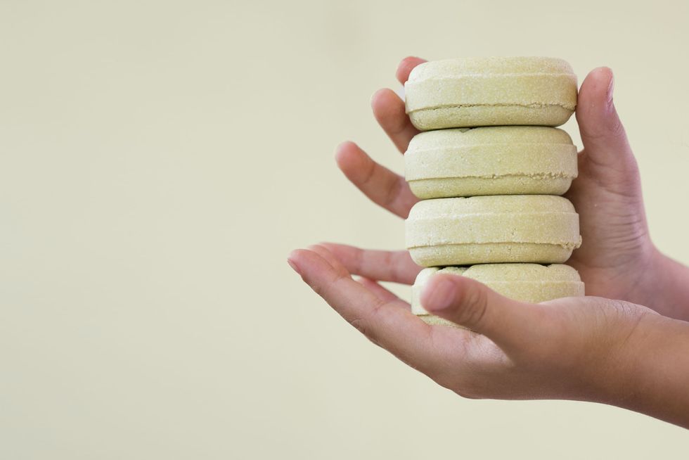 stack of organic soap and shampoo in hands