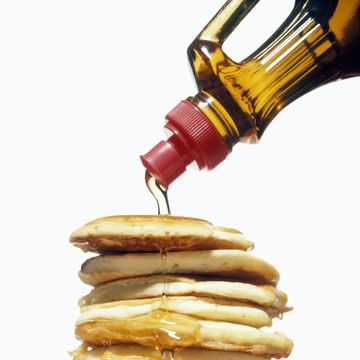 stack of pancakes on a plate with syrup pouring