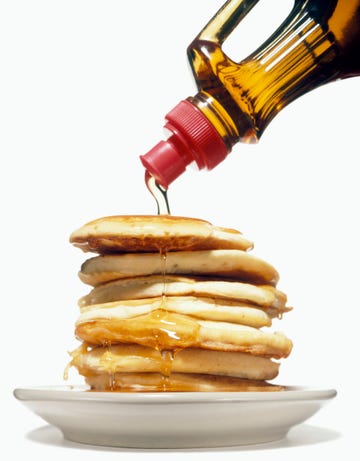 stack of pancakes on a plate with syrup pouring