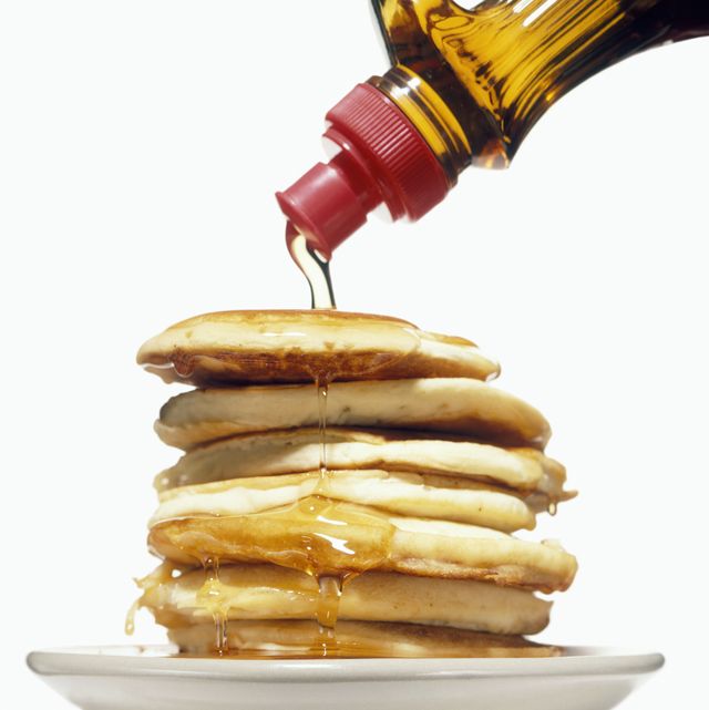 stack of pancakes on a plate with syrup pouring