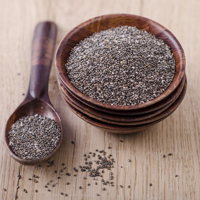 stack of wooden bowl with chia seeds and wooden spoon on wood