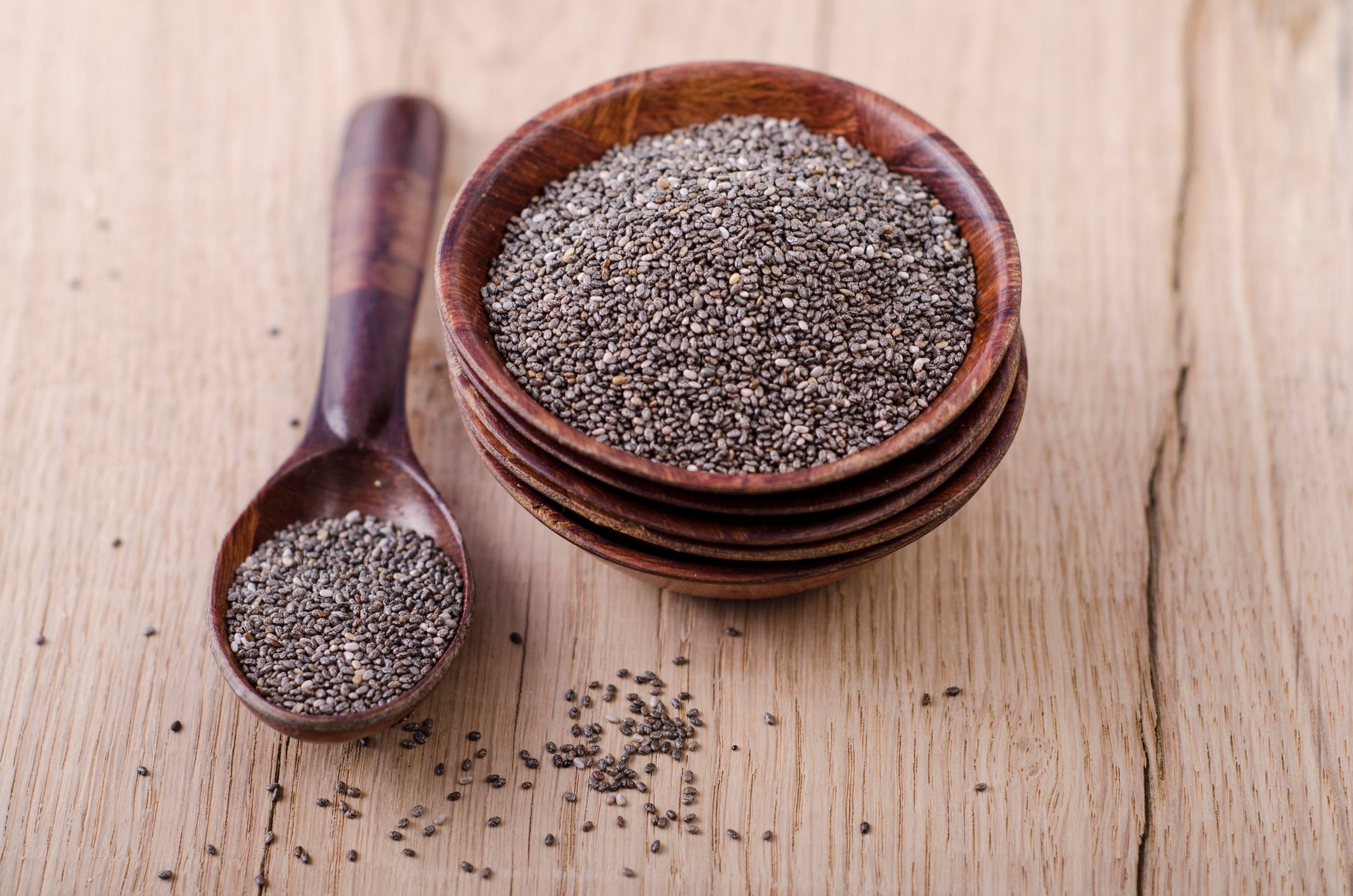 stack of wooden bowl with chia seeds and wooden spoon on wood