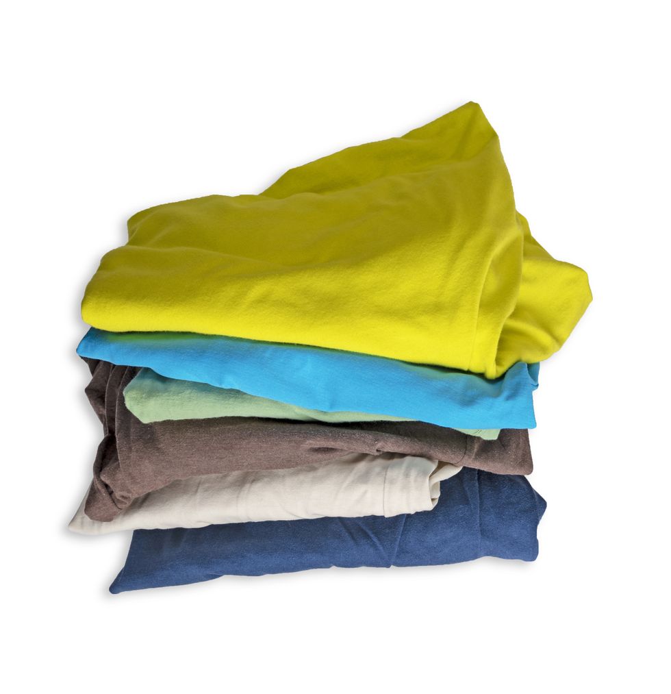 stack of worn multicolored clothes isolated on white background