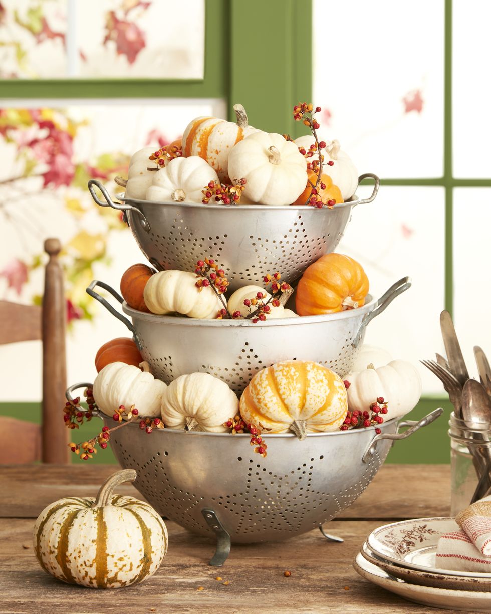 vintage stacked colanders centerpiece with mini pumpkins