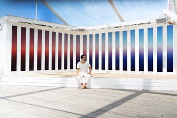 artist theo pinto sitting in front of one of his colorful art installations at the surf lodge in montauk