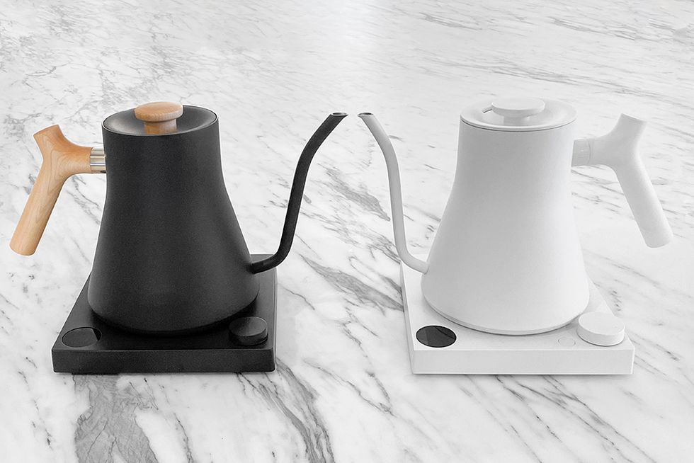 two stagg ekg electric kettles sitting on a marble surface showing two different model and color options