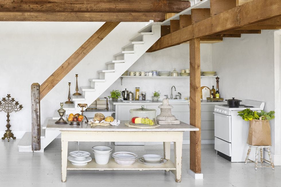 open concept room with a staircase that houses a kitchen underneath with a large island in front
