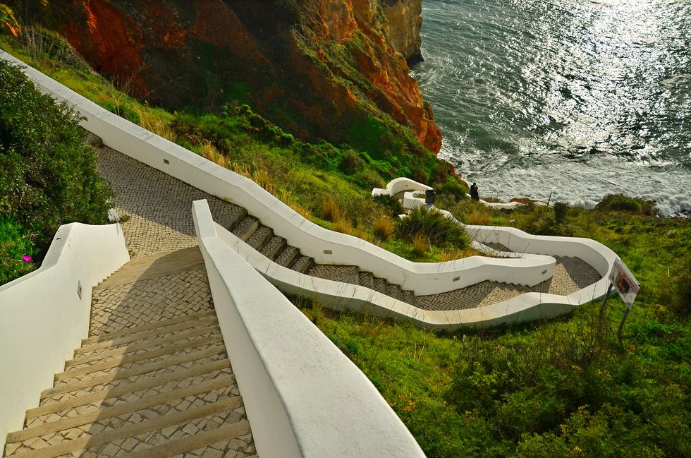 Escadas curvas e íngremes que levam à Praia Paraíso, na região do Algarve, em Portugal