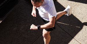 overhead view of a man running while looking at his watch
