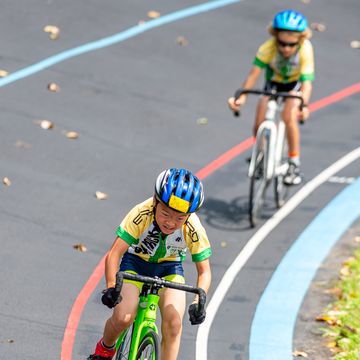 two young kids riding bikes on velodrome