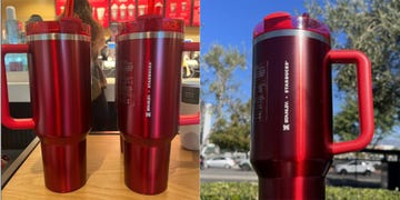 red holiday tumbler by stanley and starbucks sitting on a table