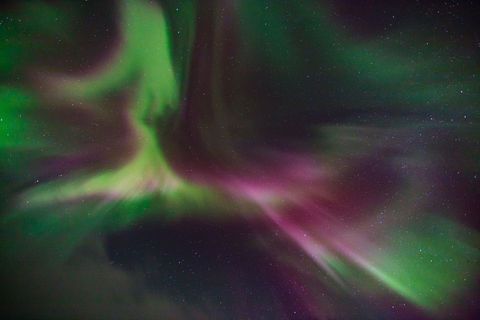 Het buitenaards ogende Noorderlicht aurora borealis ontstaat hoog in de atmosfeer wanneer geladen deeltjes van de zon in het aardmagnetisch veld worden ingevangen