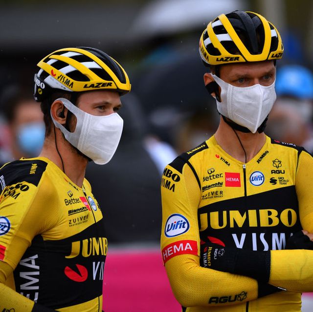 riders from team jumbo visma wearing masks