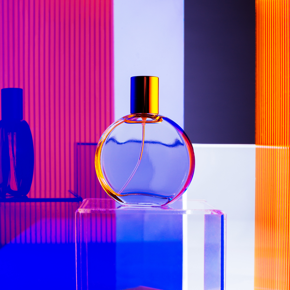 blue fragrance bottle on rainbow background