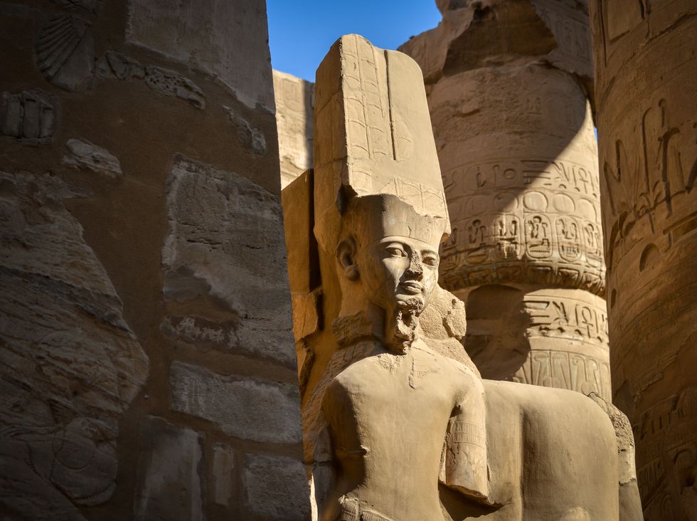 statue of the deity amun ra in the great hypostyle hall, karnak temple complex, luxor, egypt