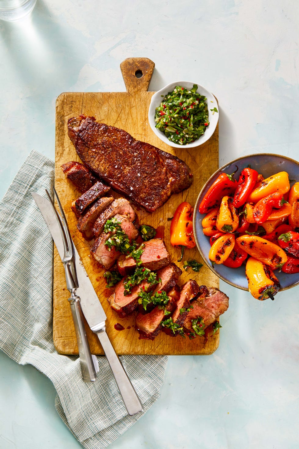 steak with chimichurri sauce on a wooden serving board