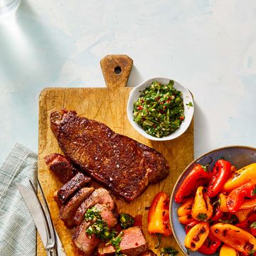 steak and grilled peppers with chimichurri sauce on the side