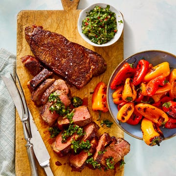 steak and grilled peppers with chimichurri sauce on the side