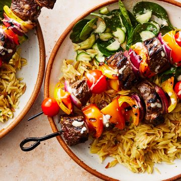 steak kebabs in a bowl with orzo and cucumber spinach salad
