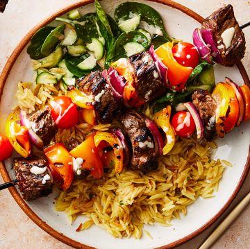 steak kebabs in a bowl with orzo and cucumber spinach salad