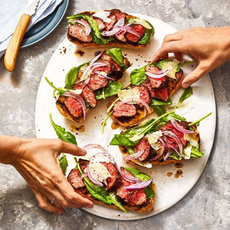 steak and arugula on a piece of toast