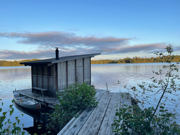 a sauna by a lake at sunset